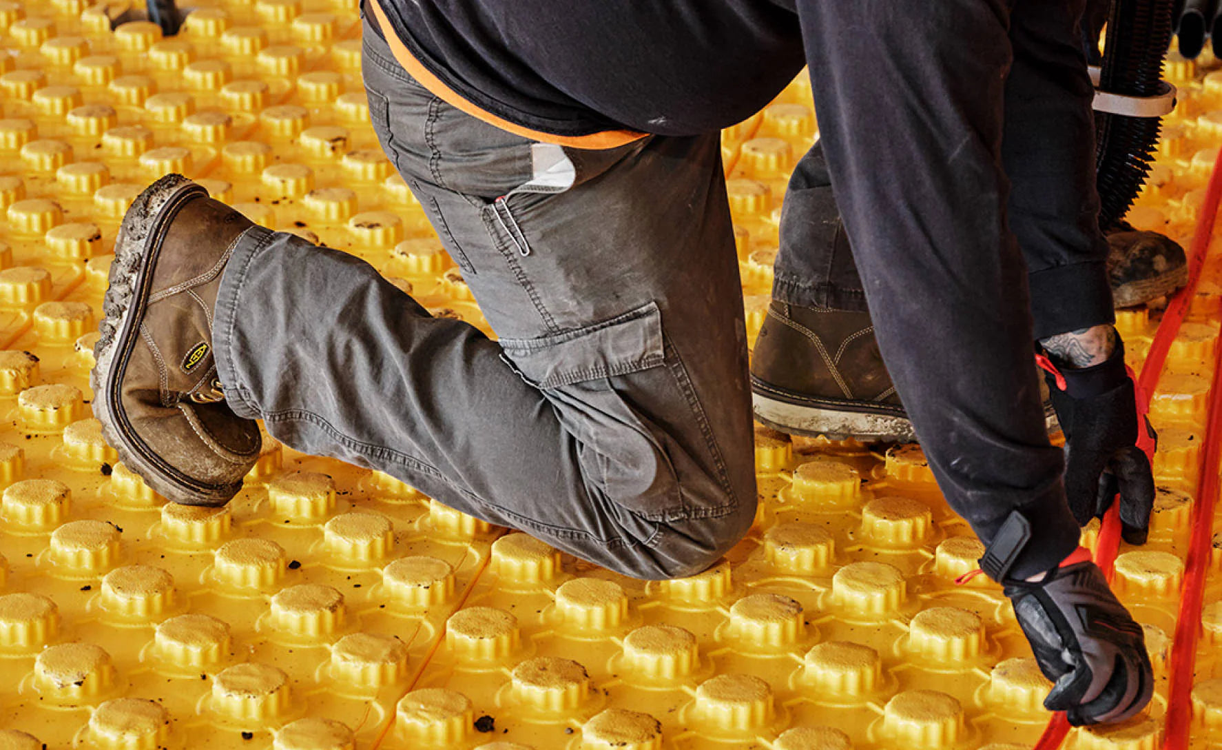 Man kneeling down while working, showcasing the Keen workboots