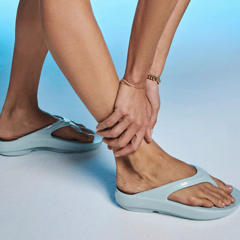 Comfy light blue thong sandals on feet, perfect for laid-back mountain adventures