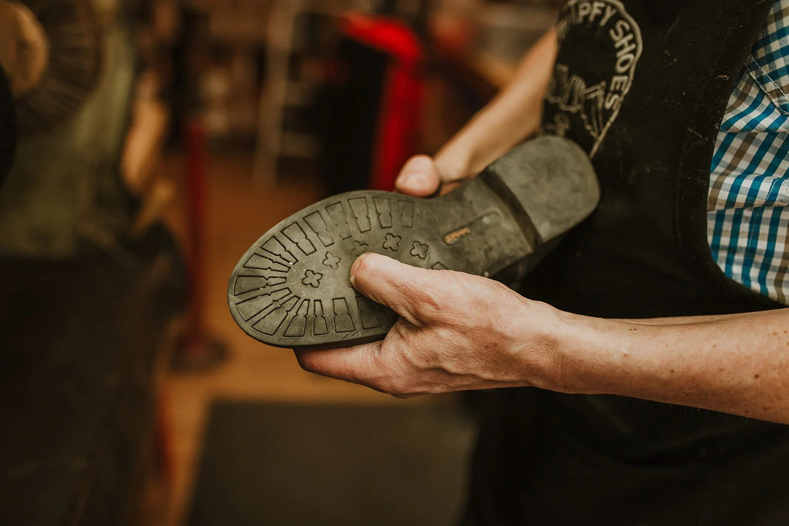 Man holding a shoe, showing its sole