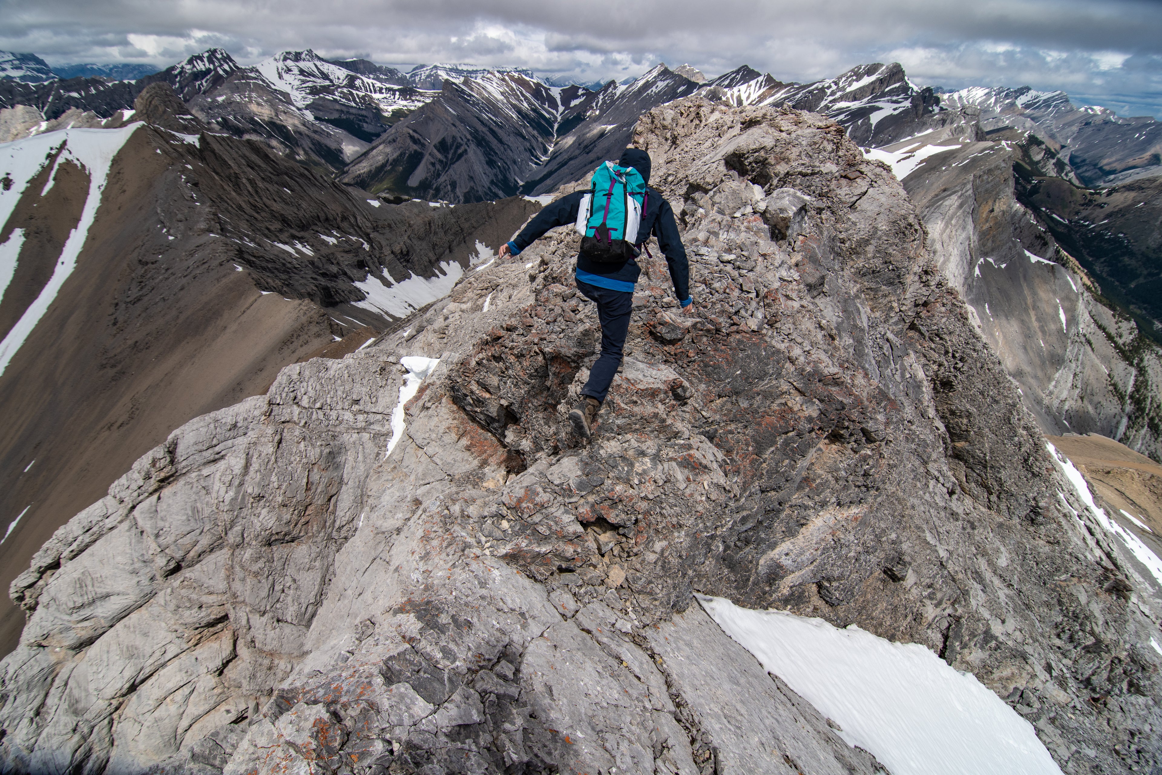 Person hiking across the ridge of a mountain in Kananaskis 