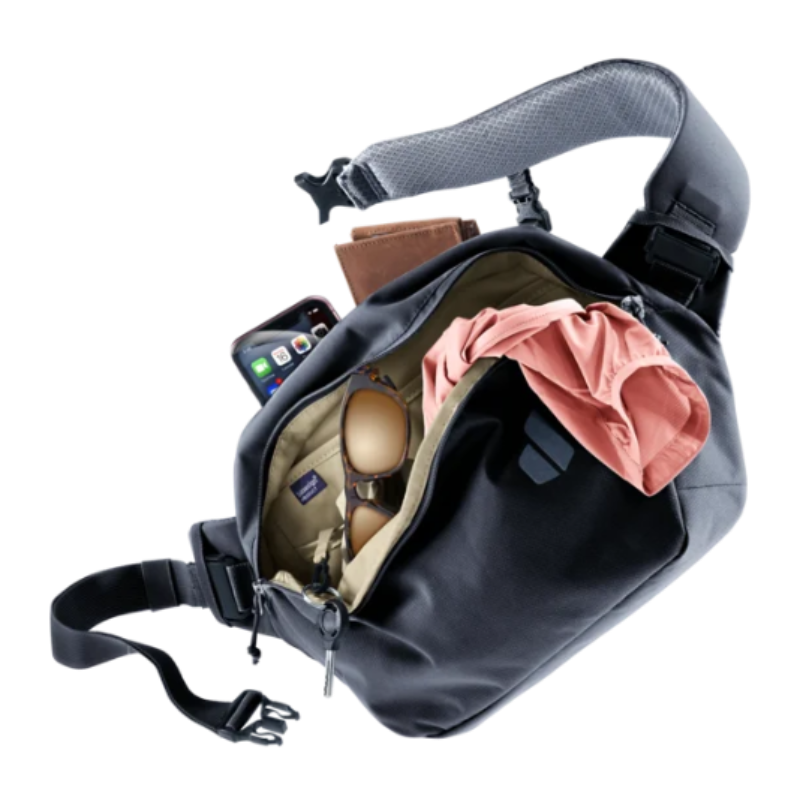 Gray crossbody bag with items like a phone, sunglasses, and a pink cloth inside on a white background